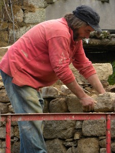 Pierre Delagnes montant un mur en pierres de granit