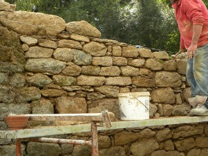 Autre vue de Pierre Delagnes montant un mur en pierres de granit